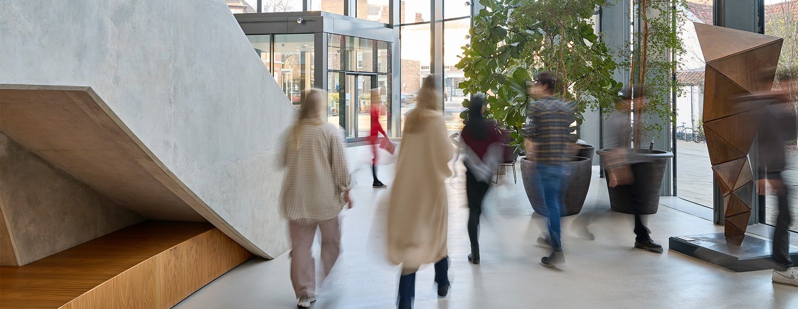 Helle Eingangshalle mit Menschen in Bewegung